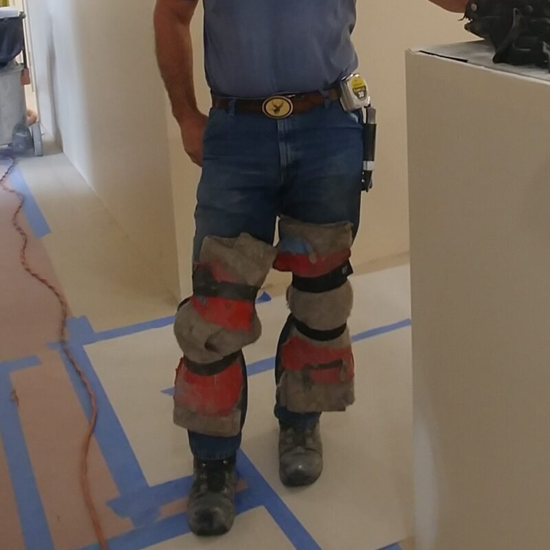 a man wearing duct taping knee carpet on his knees instead of knee pads