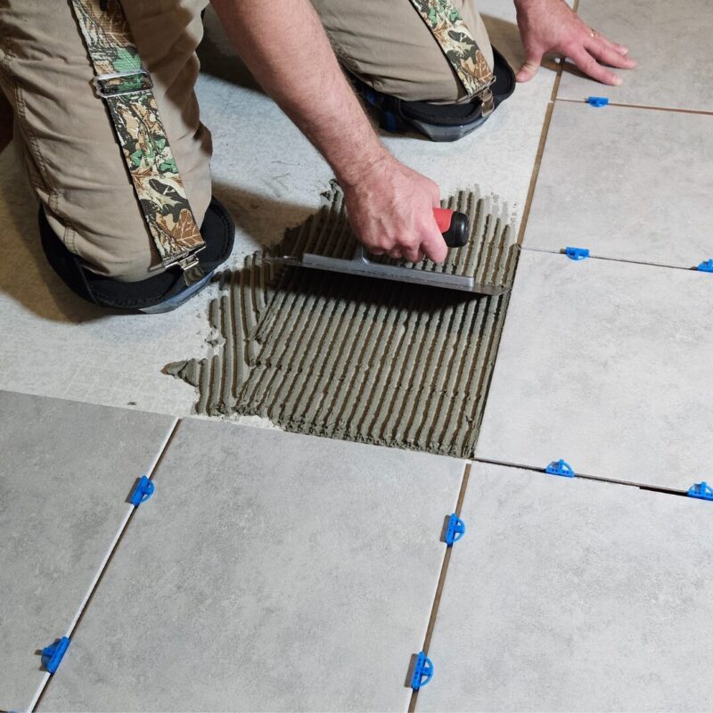 a worker installing grey tile