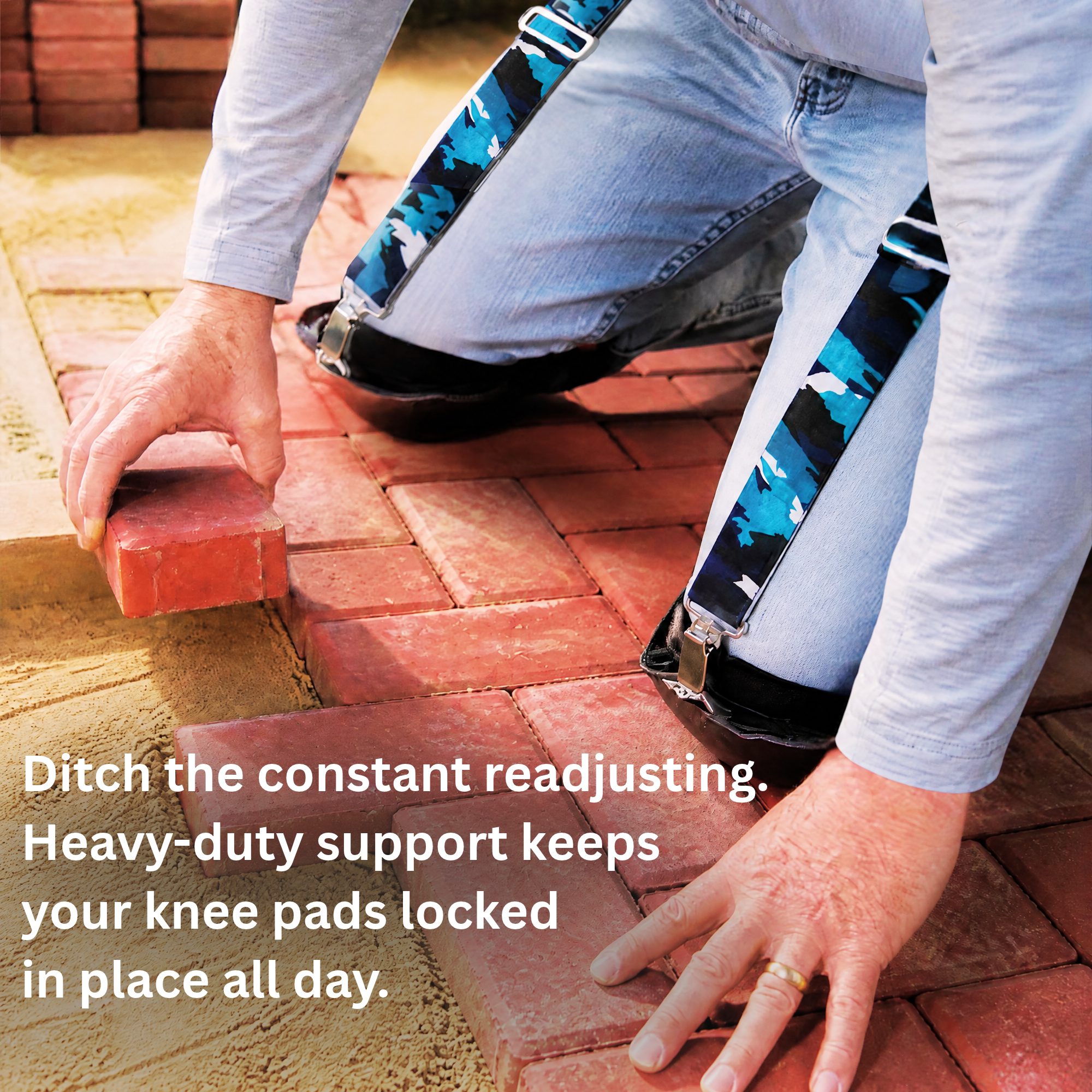 worker laying pavers on his knees while wearing knee pad hangers to hold up his knee pads